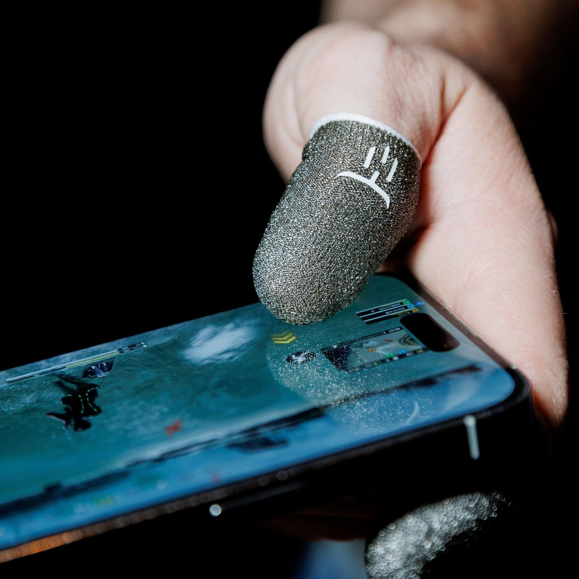 Hand holding a smartphone with a protective foam cover thumb sleeves on the screen