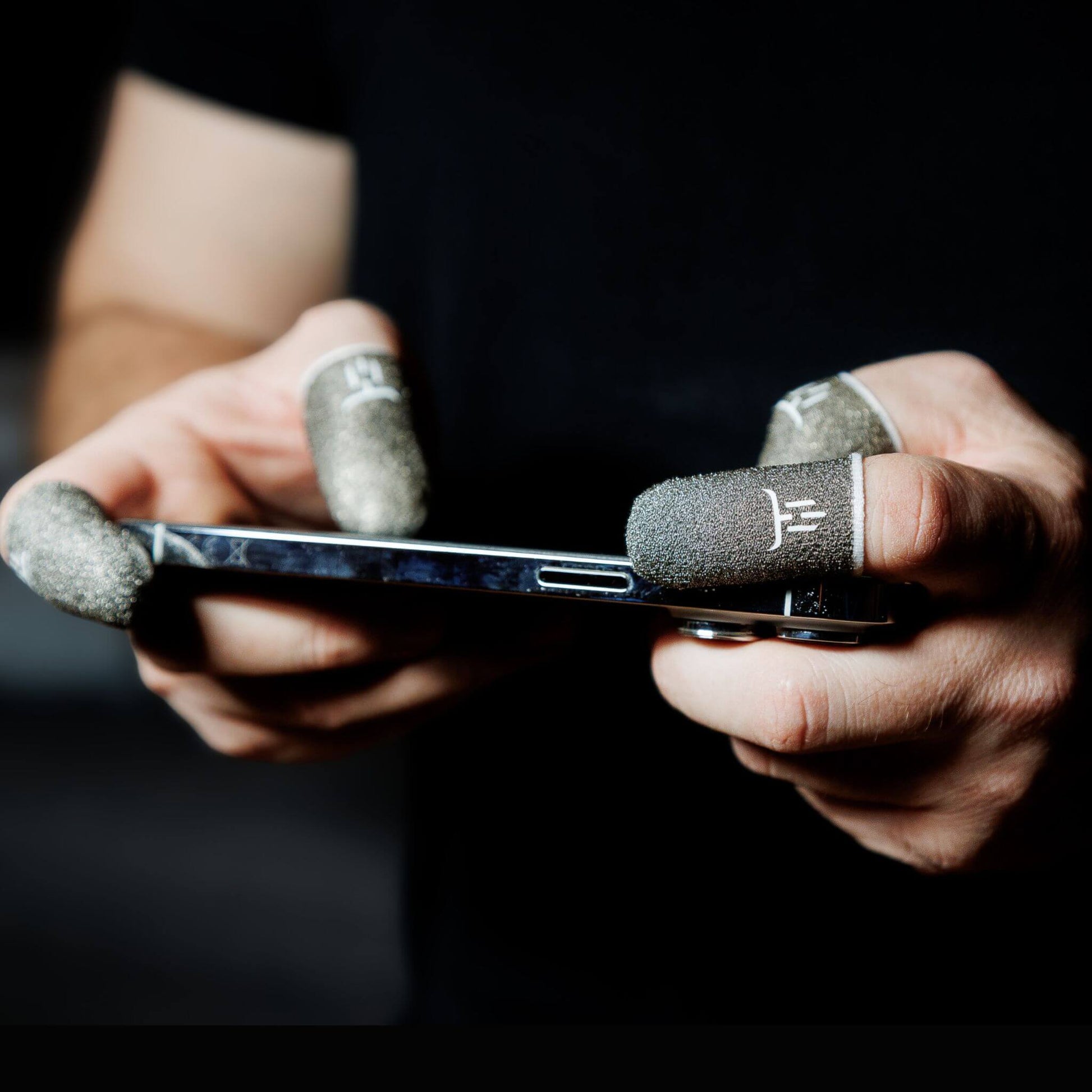 Person holding a smartphone with unique grip design finger sleeves