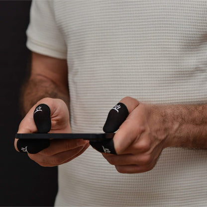 Person holding a smartphone with black phone cases on each hand, wearing a gaming finger sleeves