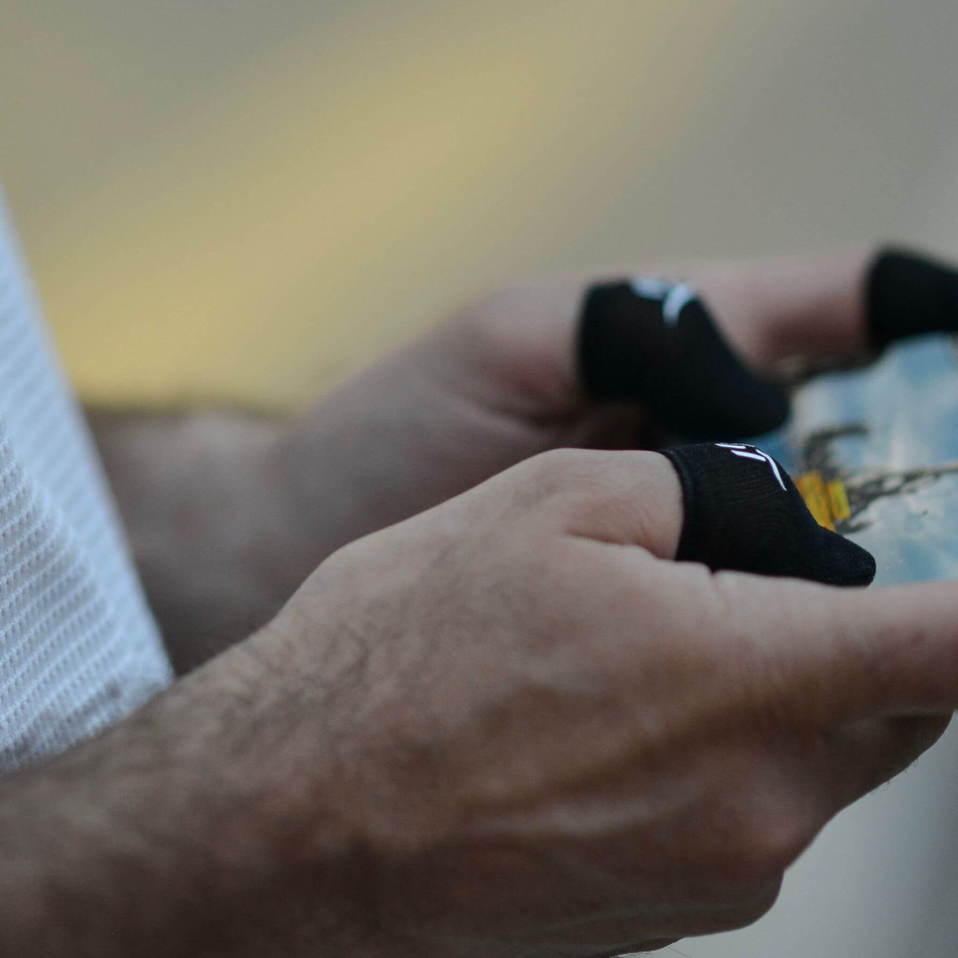 Close-up of hands holding a smartphone with the best finger sleeves