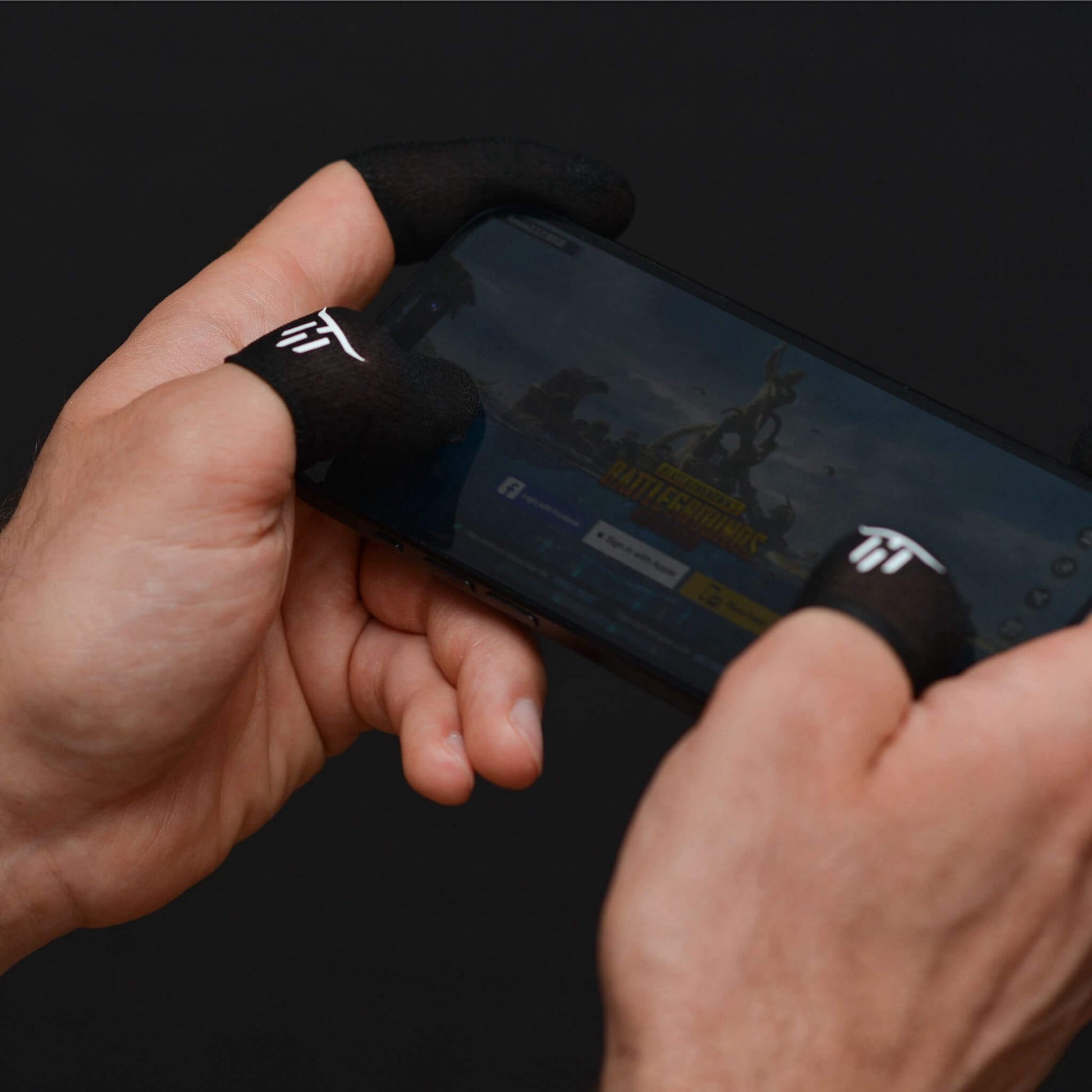 Person holding a smartphone with a dark screen, wearing minoansocks finger sleeves